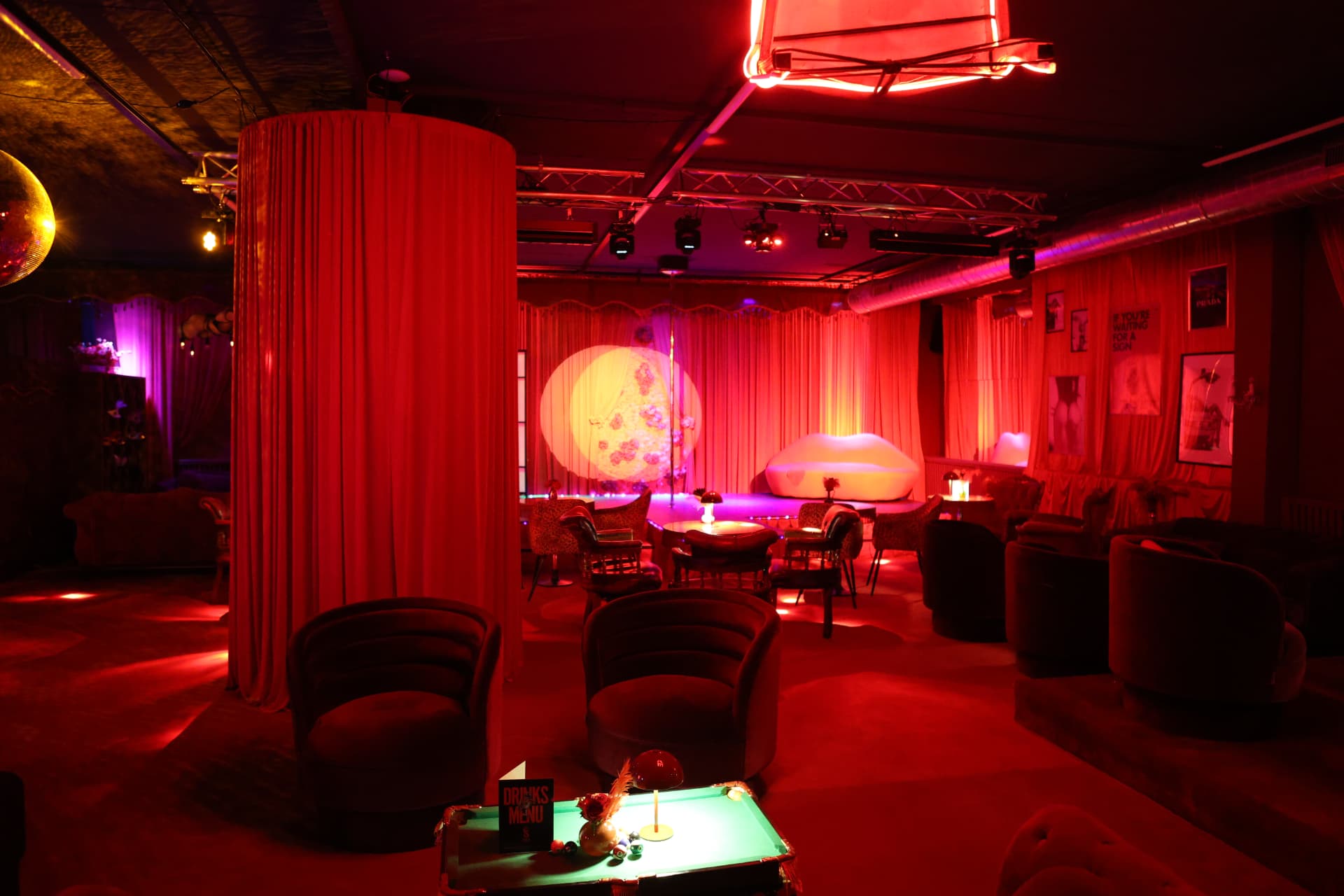 Rote Club-Lounge mit beleuchteter Bühne